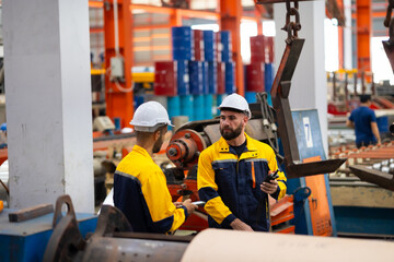 remote control overhead crane : engineer worker working control sheet metal roof machine at metal sheet profiling factory. Industrial production. Service and Maintenance of factory machinery