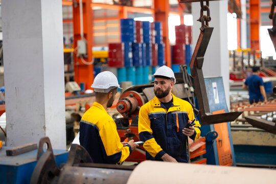 remote control overhead crane : engineer worker working control sheet metal roof machine at metal sheet profiling factory. Industrial production. Service and Maintenance of factory machinery - Powered by Adobe