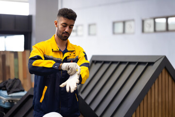 Wear gloves and get ready to work : Hispanic man Professional Mechanical Engineer in safety hardhat Working Maintenance sheet metal roof tile roll forming machine at industrial manufacturing factory