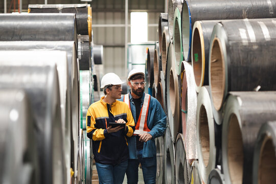 Steel Rolls in Steel Mill. Professional Mechanical Engineer team employees checking production line in wire warehouse. Engineer checking steel rolls. Product quality Inspection