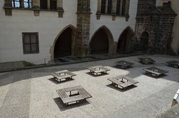 Old square-shaped benches placed in a church square.