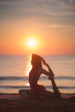 Woman Practicing Yoga on Beach at Sunrise in Elegant Pose