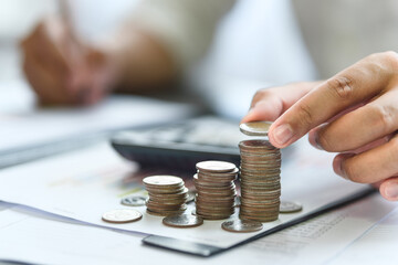 Concept of Finance. Budgeting. Taxes. Accounting, Investment. Businessman stacking coins and doing...
