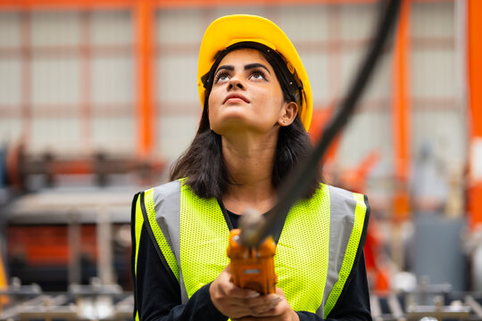 remote control overhead crane : Indian female engineer worker working control sheet metal roof machine at metal sheet profiling factory. Industrial production. Maintenance of factory machinery - Powered by Adobe