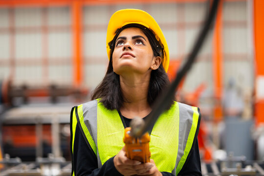 remote control overhead crane : Indian female engineer worker working control sheet metal roof machine at metal sheet profiling factory. Industrial production. Maintenance of factory machinery