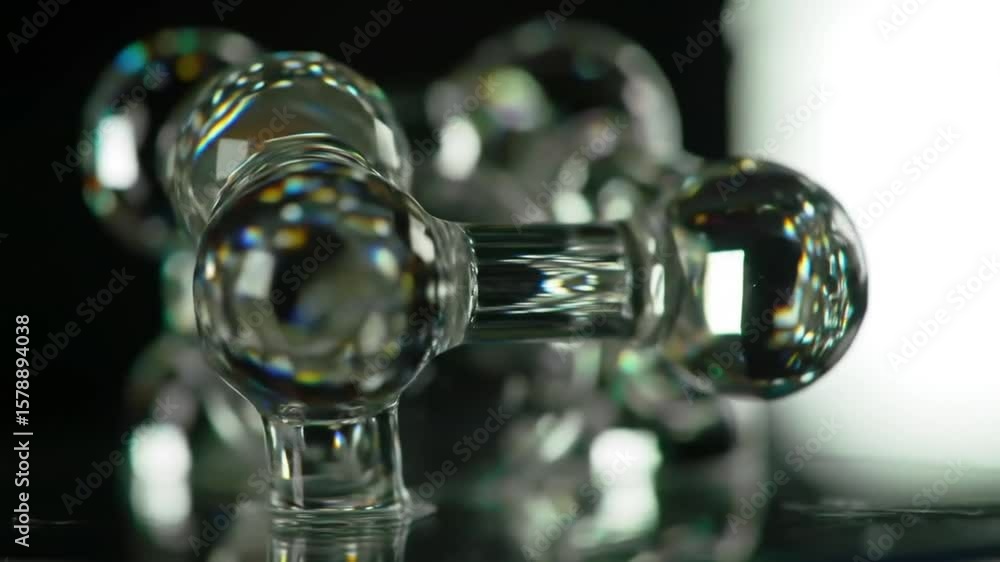 Poster interconnected transparent spheres reflecting light on a glossy surface with a dark background and c