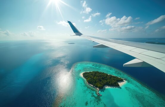 Airplane wing soars above tropical island in serene aerial view. Crystal clear blue water reflects sunlight creating vacation travel mood. Scenic picturesque landscape, summer holidays, paradise