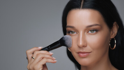 Glamorous Woman Enhancing Her Beauty With a Makeup Brush