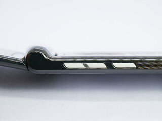 Close up of Side View of Foldable Smartphone (Flip Phone) Showing Volume Buttons and Speaker Grill on White Background