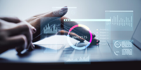 Business analytics dashboard with digital KPI graphs and data analysis interface displayed over hands typing on laptop keyboard in soft light setting.