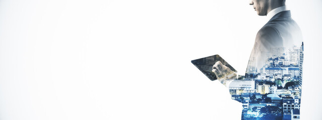 Businessman using tablet with cityscape double exposure on white background for digital technology...
