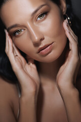 Obraz premium Elegant Woman with Tanned Skin and Captivating Eyes in Relaxed Pose