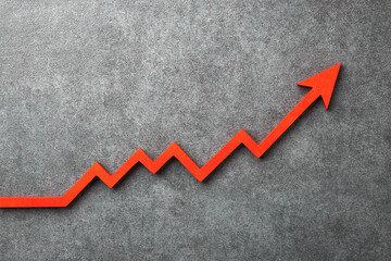 A red upward arrow on a stone background, symbolizing growth or rising trends in finance or...