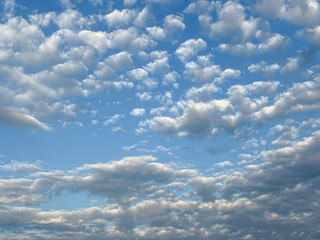A sky filled with scattered cumulus and stratocumulus clouds against a vivid blue backdrop.