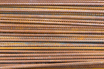 Rusty metal rebar rods arranged in parallel at construction site