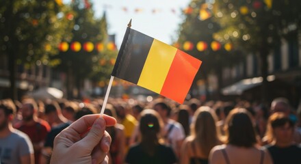 Hand Holding a Belgian Flag in a Festival Crowd