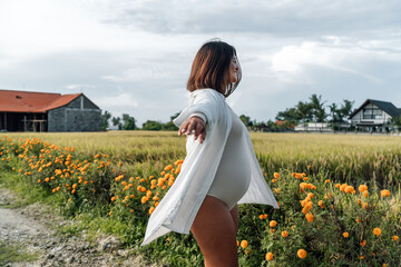 Side view of pregnant woman with arms open, symbolizing full surrender and conscious distance from...