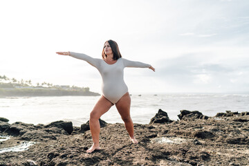 Pregnant woman stands in confident wide stance with arms extended, practicing focus and inner...