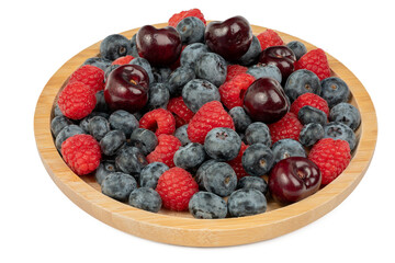 The High resolution fruit photo of mixed fruits including cherries, raspberries and blueberries arranged on a plate, taken with split focus technique.