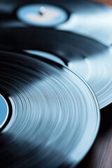 Vinyl records are stacked closely together, showcasing their grooves and reflections. Vintage music and nostalgia
