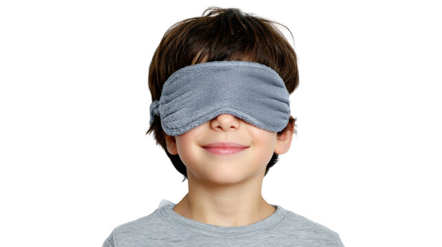 Happy boy wearing a sleep mask, smiling, isolated on white background.