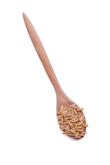 The High resolution photograph of oats placed on a wooden spoon and spread on a white background, taken with split-focus technique.