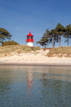 Blick vom Wasser auf den kleinen Leuchtturm am Gellen auf der Insel Hiddensee - Hochformat