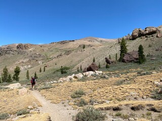 Hiking through scenic mountainous terrain on a sunny day in a remote wilderness area