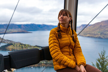 A girl enjoys a ride on Skyline Queenstown Gondola, the steepest cable car in the Southern...