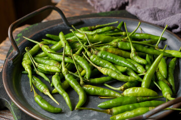 Fresh Green Bird’s Eye Chilies on Wooden Background for Asian Cuisine and Natural Cooking Ingredients