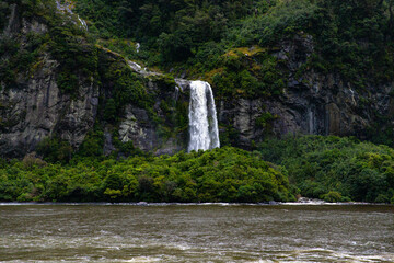 beautiful Bridal Veil Falls falling from dramatic mountain cliffs during heavy rainfall, scenic...