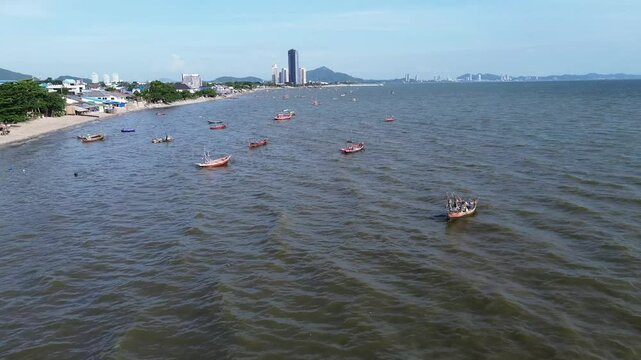 Aerial view of Bang Saen beach, fishing boats, and tall buildings, Thailand.