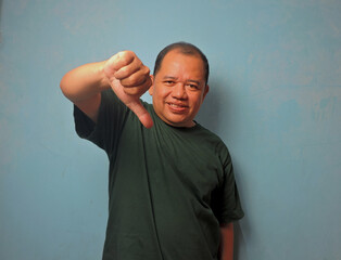 Middle Aged Man Showing Thumbs Down Gesture with Disapproving Expression