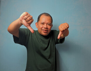Disapproving Middle Aged Man Showing Thumbs Down Gesture