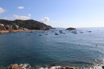 Rocks and stones of the Mar Menuda beach of Tossa de Mar in the south of the Costa Brava in summer