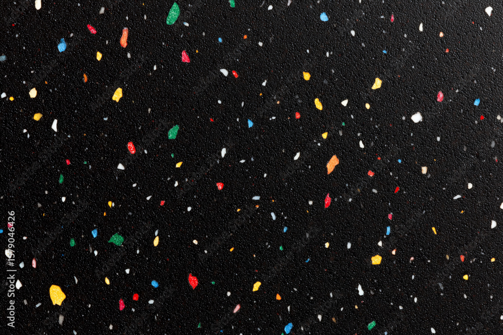 Poster a dark surface speckled with colorful fragments scattered randomly around it