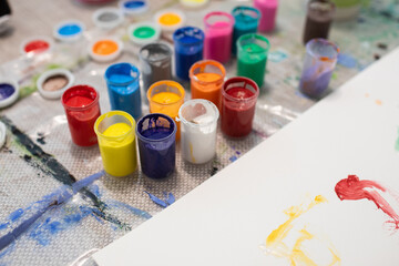 Jars of colorful paint for drawing on a table
