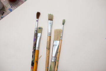 Paint brushes on a white sheet of paper on the table