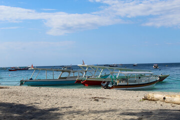 Traditional Boats Floating on Blue Sea Near Sandy Beach in Gili Trawangan, Lombok Indonesia. with...