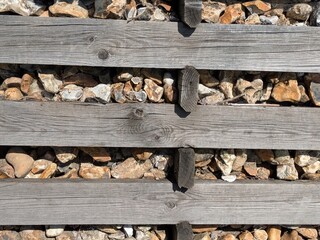 Old wooden railway tracks planks with stones and pebbles as a background