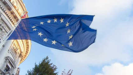 European flag waving energetically against a vibrant sky near historic architecture - Powered by Adobe