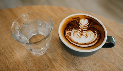 coffee latte art on wood table,A perfectly brewed cappuccino adorned with beautiful latte art, ideal for a morning treat or cafe indulgence.