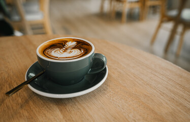 coffee latte art on wood table,A perfectly brewed cappuccino adorned with beautiful latte art, ideal for a morning treat or cafe indulgence.