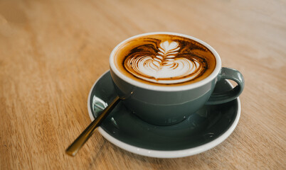 coffee latte art on wood table,A perfectly brewed cappuccino adorned with beautiful latte art, ideal for a morning treat or cafe indulgence.
