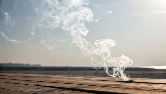 Wisps of white smoke rise and curl gently above a wooden surface against a clear sky backdrop. - Powered by Adobe