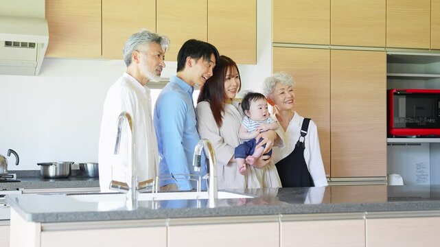Smiling three-generation family surrounding a baby