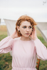 Red-haired woman in pink dress outdoors