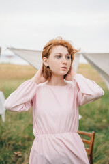 Red-haired woman in pink dress outdoors