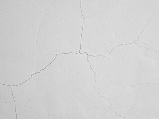 Background of hairline crack on white painted concrete wall. Fine cracks on the wall are caused by...