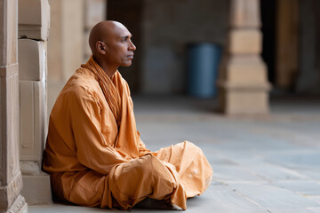 Fototapeta premium Hindu monk meditating in temple courtyard, early morning light, spiritual mood, 